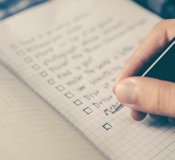 person writing bucket list on book