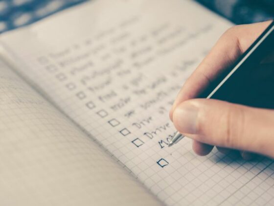 person writing bucket list on book