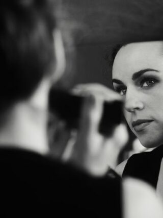 a woman is looking in the mirror while brushing her teeth