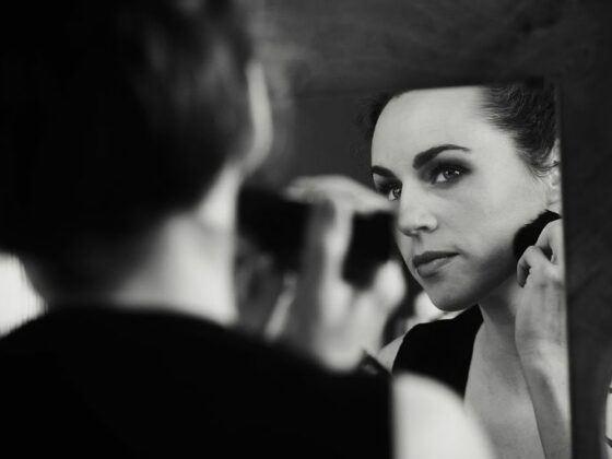 a woman is looking in the mirror while brushing her teeth