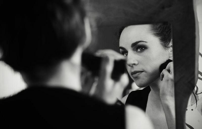 a woman is looking in the mirror while brushing her teeth