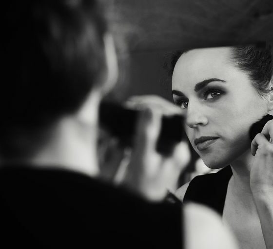 a woman is looking in the mirror while brushing her teeth